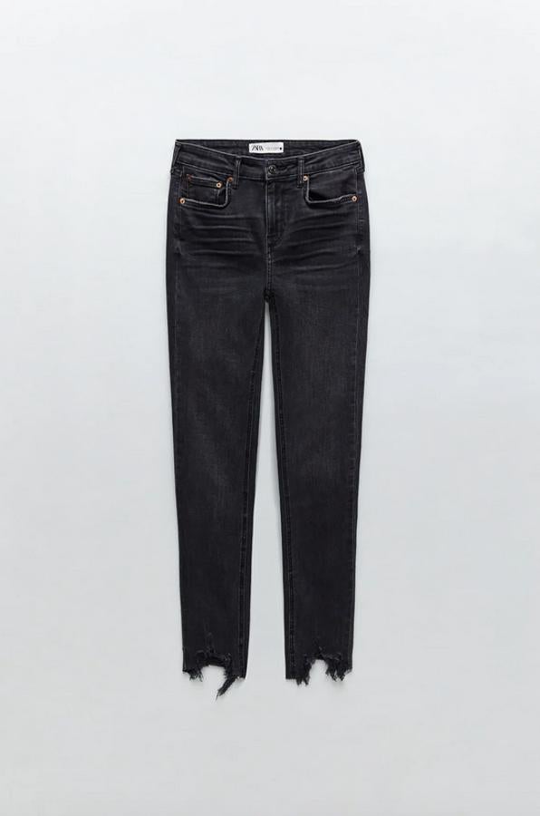 De tiro medio, con pernera skinny y bajo con acabado deshilachado y desigual, estos jeans negros de Zara tienen un precio de 29,95 euros y están disponibles entre las tallas 34 y 44.