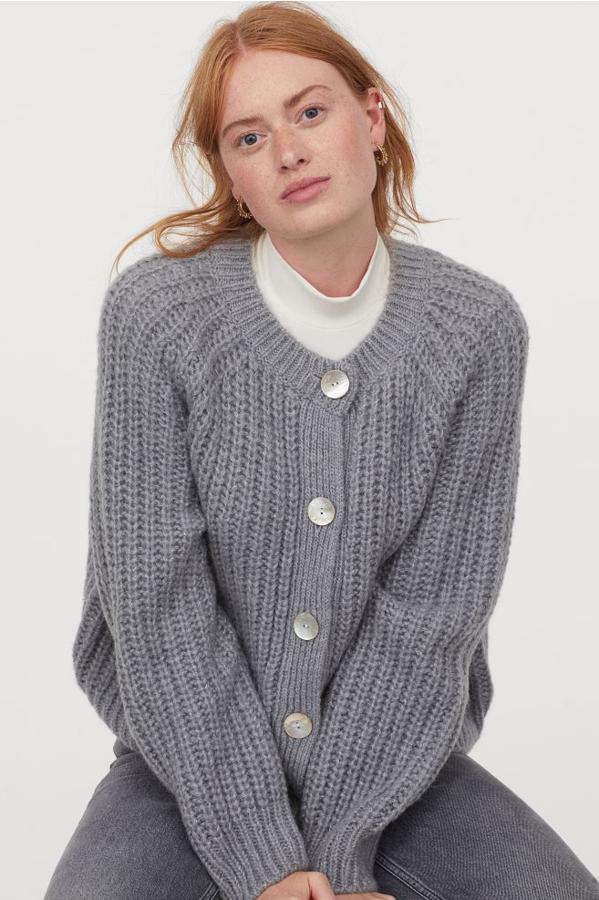 De venta exclusiva en la web de H&M, este cárdigan en punto de canalé suave de mezcla de lana viene con mangas raglán con hombros caídos, cierre hasta el cuello redondo y botones de concha delanteros. Cuesta 49,99 euros y está disponible entre las tallas XS y XXL.