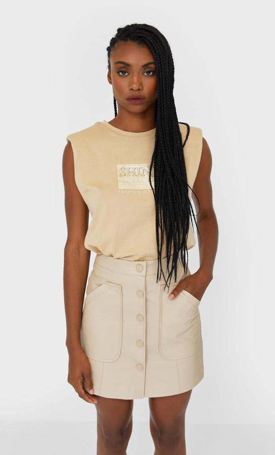 De tiro alto, con cierre frontal de botones a presión a tono y bolsillos de plastrón en el frontal, esta falda mini en color piedra de Stradivarius tiene un precio de 17,99 euros y está disponible entre las tallas 32 y 44.