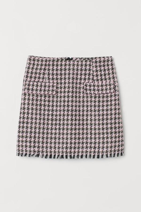 Estampado pata de gallo en tonos rosas y negros para esta minifalda de H&M en tejido grueso con bolsillos decorativos delante y bajo con flecos cortos. Cuesta 24,99 euros y está disponible entre las tallas 32 y 50.
