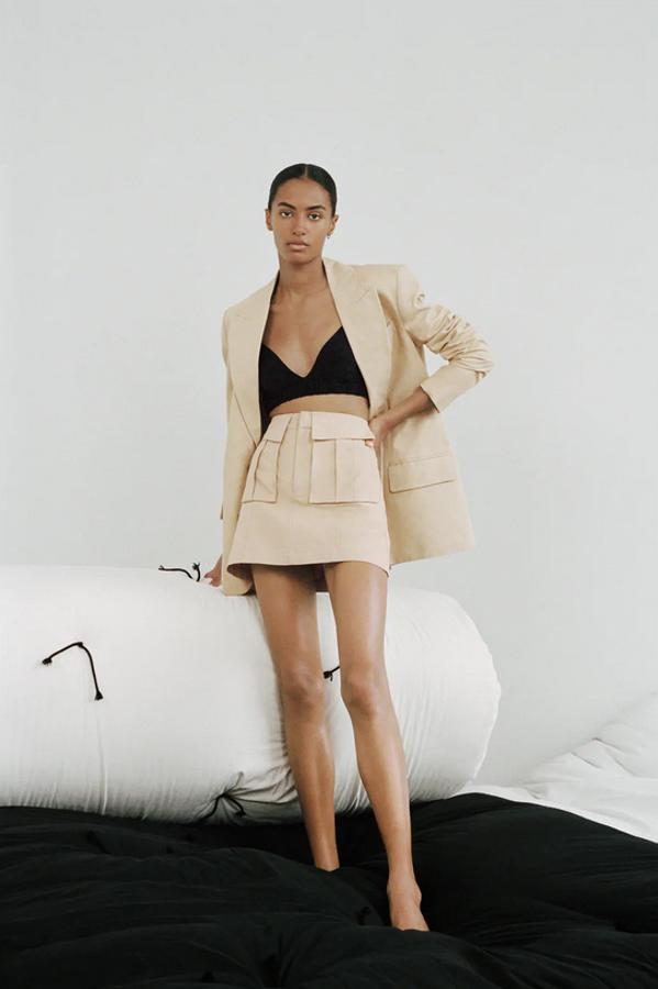 Confeccionada con tejido en mezcla de lino de tiro alto, esta minifalda en camel claro de Zara viene con bolsillos de plastrón con solapa y cierre de cremallera en el frontal. Cuesta 22,95 euros y está disponible entre las tallas XS y XL.