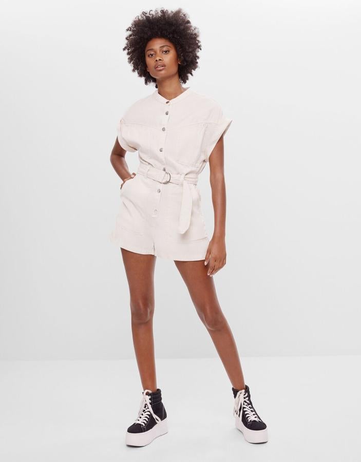 En color arena, con cierre de botones metálicos a presión, este mono corto utility de Bershka viene con mangas cortas amplias y bolsillos delanteros de plastrón. Cuesta 25,99 euros y está disponible entre las tallas XS y L.