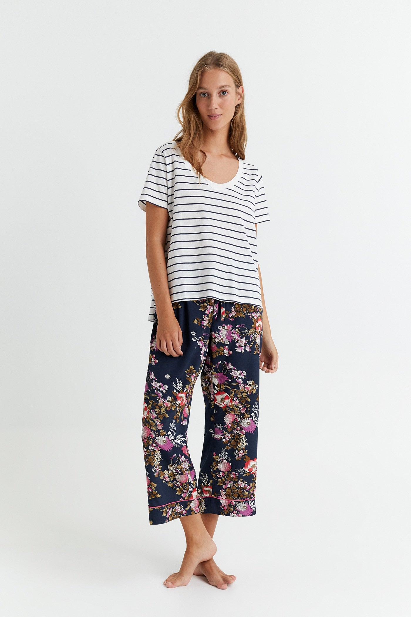 Escote amplio y redondo, tejido fluido y mangas XXL. Camiseta blanca de rayas de Sfera. (6,99 euros).