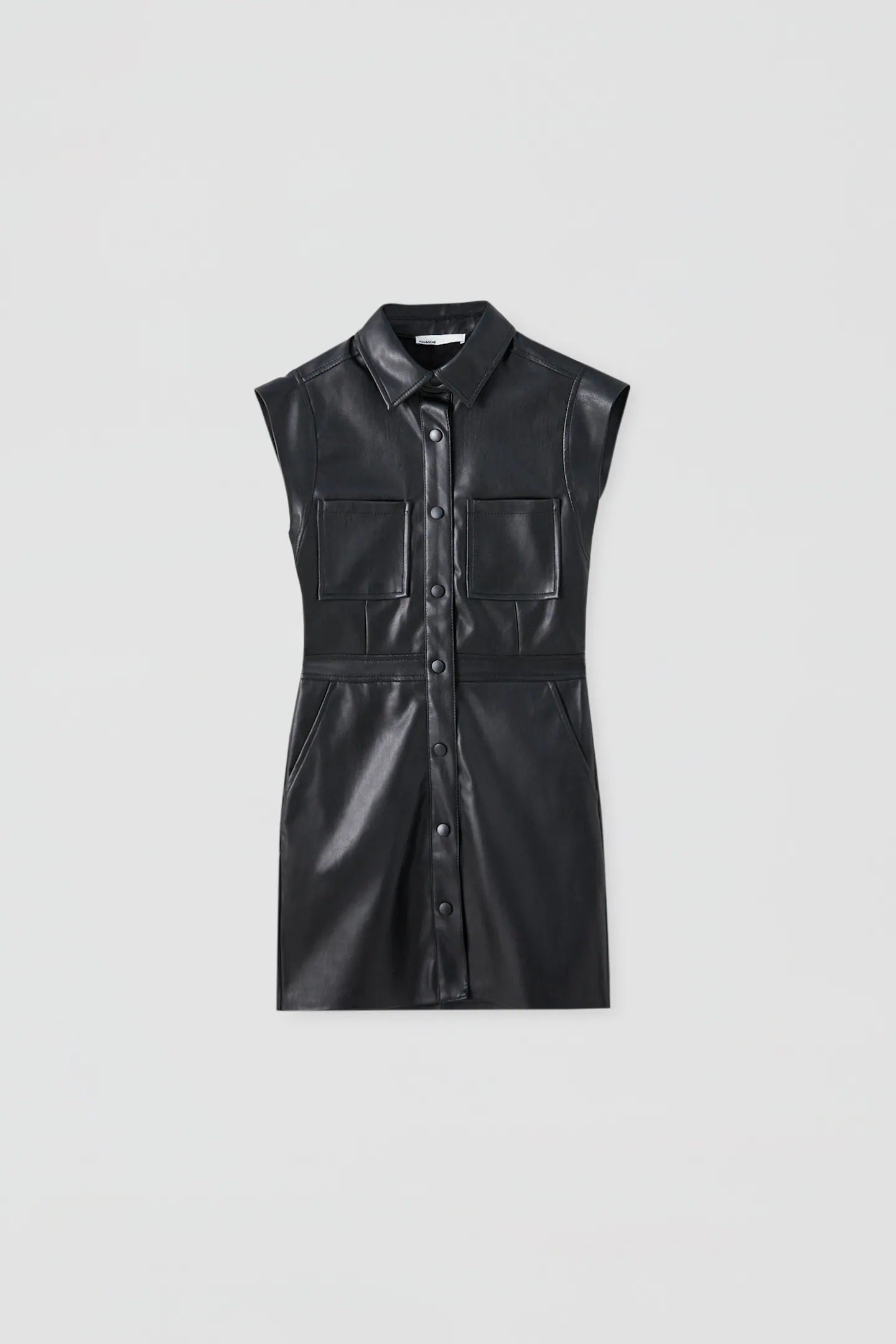 Vestido camisero de polipiel en negro. Ideal para combinar este otoño con botas altas, cazadora vaquera o chaqueta de punto. (25,99 euros).