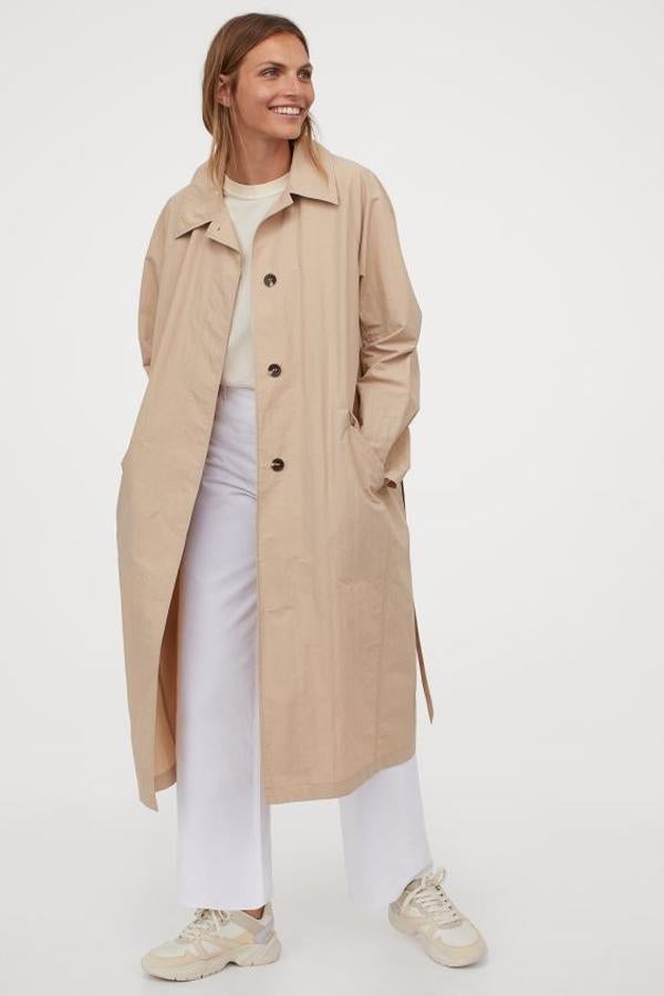 Confeccionada en mezcla de nailon y algodón, esta gabardina beige de H&M viene con mangas raglán, bolsillos al bies ribeteados, botones ocultos delanteros y cinturón a tono. Cuesta 49,99 euros y solo se puede comprar en la web de la firma entre las tallas XS y XXL.