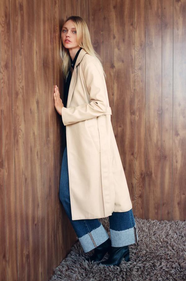En color arena, con cuello solapa y bolsillos laterales, esta gabardina en efecto piel de Zara viene con bajo con aberturas laterales y cinturón con lazada en el mismo tejido. Tiene un precio de 49,95 euros y está disponible entre las tallas XS y XL.