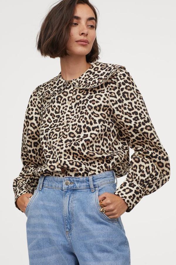 Con fondo en beige y cuello amplio doble ribeteado con volante, esta blusa vaporosa de algodón de H&M tiene diseño recto, puños amplios abotonados y bajo redondeado asimétrico. Con un precio de 19,99 euros, está disponible entre las tallas XS y XXL.