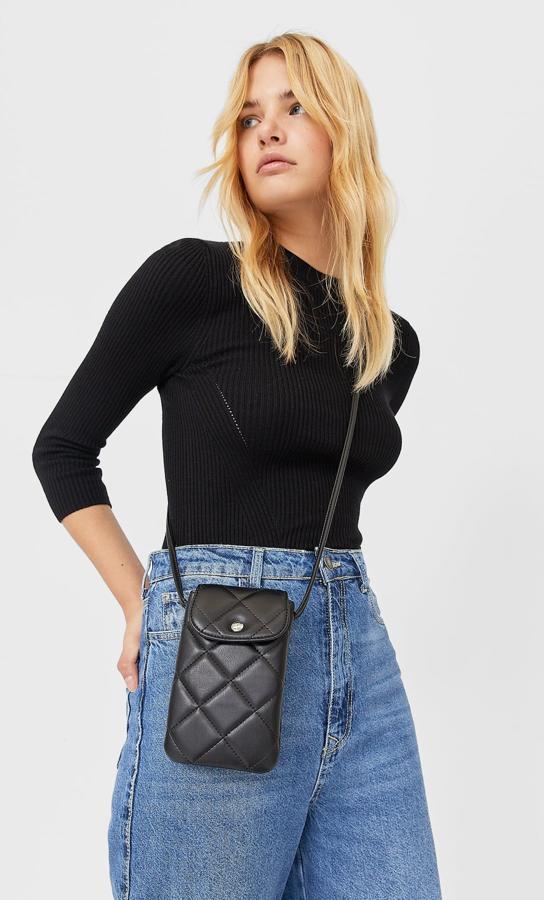 Después de los colgantes para el móvil llegan los bolsitos para el móvil. Son de pequeño tamaño y se llevan en bandolera. Este acolchado en color negro lo puedes encontrar por muy poco dinero en Stradivarius (9,99 euros).