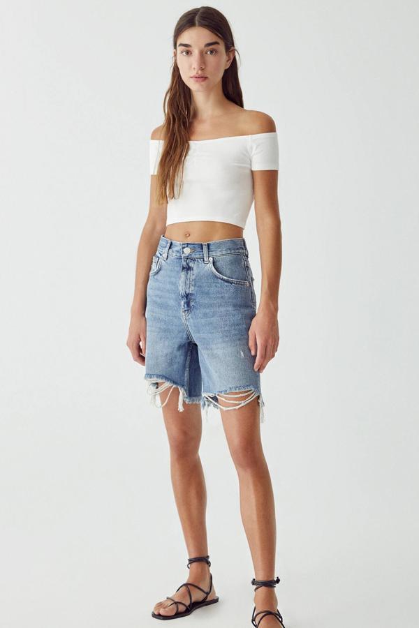 En color azul, esta bermuda vaquera de tiro alto con diseño de cinco bolsillos y cintura con trabillas está confeccionada en 100% algodón. Tiene un precio de 25,99 euros.