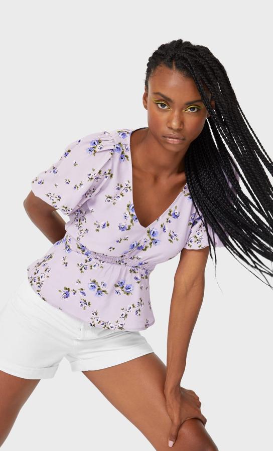 En tono malva, esta blusa con escote de pico y manga corta abullonada cuenta con volantes en el bajo y tiene un precio de 11,19 euros. Está disponible en otros colores.