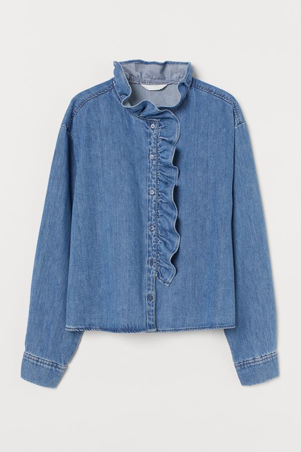 Esta blusa recta denim en algodón suave en color azul cuenta con volante en el cuello que se prolonga por los botones. Tiene un precio de 24,99 euros.
