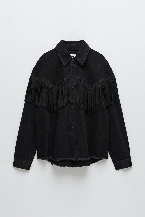 En color negro, esta cazadora denim de cuello solapa y manga larga acabada en puño cuenta con detalle de flecos y bajo desflecado. Es de Zara y tiene un precio de 29,95 euros.