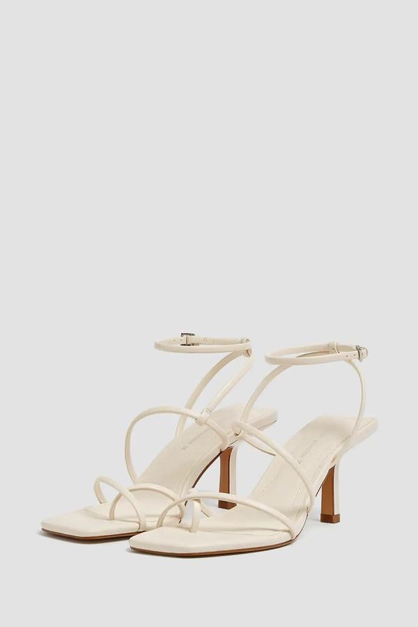 En color crudo, esta sandalia de tacón de 8 centímetros y detalle de tiras cuenta con cierre mediante hebilla alrededor del tobillo. Es de Pull & Bear y tiene un precio de 25,99 euros.