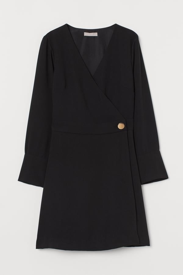 En color negro, este vestido corto con escote de pico cruzado cuenta con manga larga acabada en puños anchos y botón de metal en un lateral. Tiene un precio de 29,99 euros.