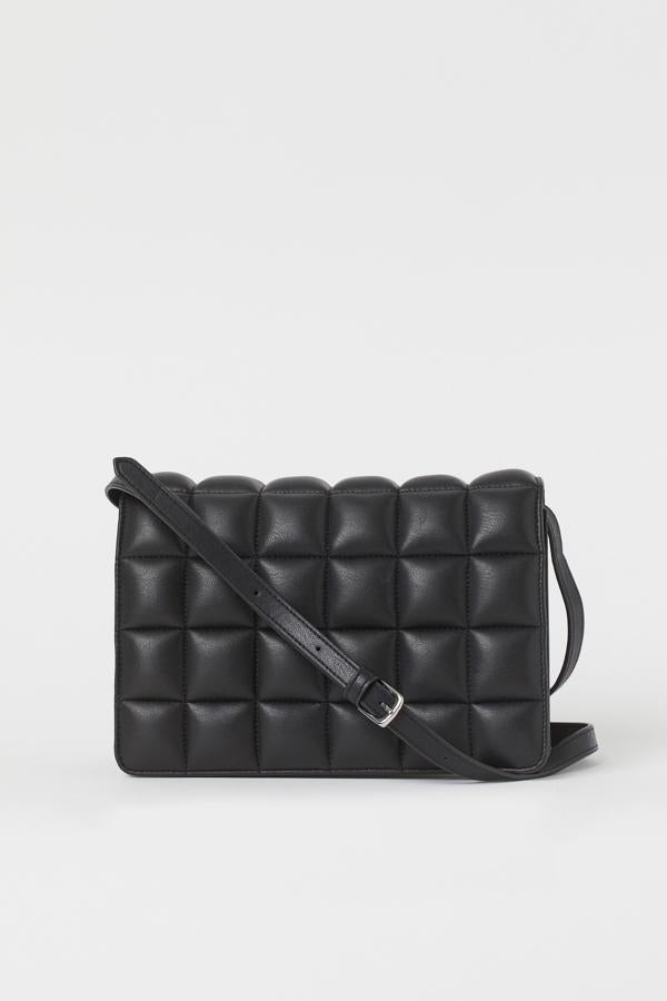 En piel sintética guateada, con correa fina ajustable, solapa con cierre magnético y compartimento interior con cremallera, este bolso bandolera en color negro y diseño de cuadros es de H&M y cuesta 19,99 euros.