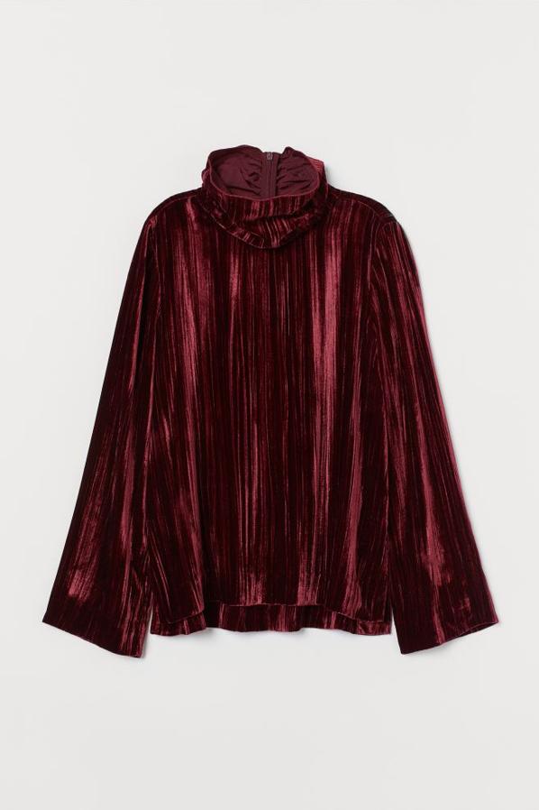 En rojo oscuro, con mangas largas y cuello alto ribeteado alto, este top de manga larga de H&M viene con mangas rectas amplias y aberturas laterales. Cuesta 89,99 euros y está disponible entre las tallas 32 y 38 y en la 44, además de en color negro.