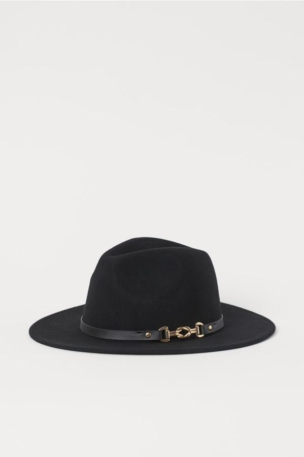 Con cinta de cuero alrededor de la copa y detalle de cierre dorado, este sombrero grueso en lana de fieltro tiene una ancho de ala de siete centímetros. Es de H&M, cuesta 24,99 euros y está disponible únicamente en la talla L.