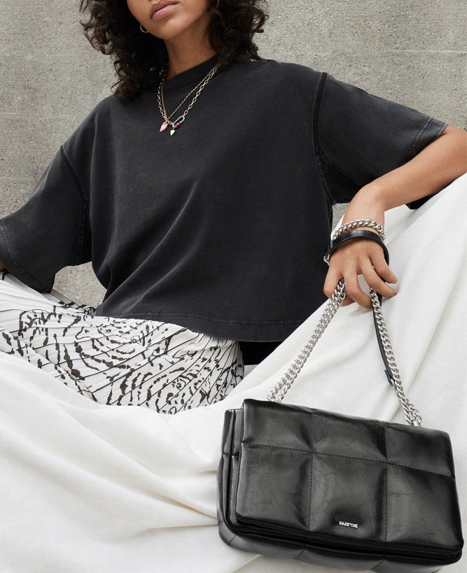 Las faldas son otro imprescindibles para el entretiempo. Ideal para combinar con cualquier camiseta básica, como una negra en este look de Parfois.