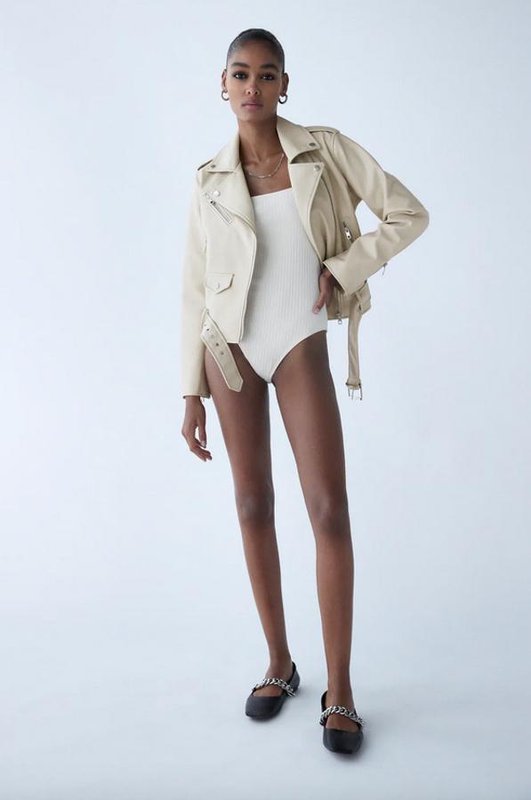 Con cuello de solapa y mangas largas, esta cazadora biker en efecto piel y color crudo de Zara viene con bolsillos delanteros con cremallera metálica, detalle de trabillas en los hombros y cinturón a tono con hebilla. Tiene un precio de 39,95 euros y está disponible entre las tallas XS y XXL.