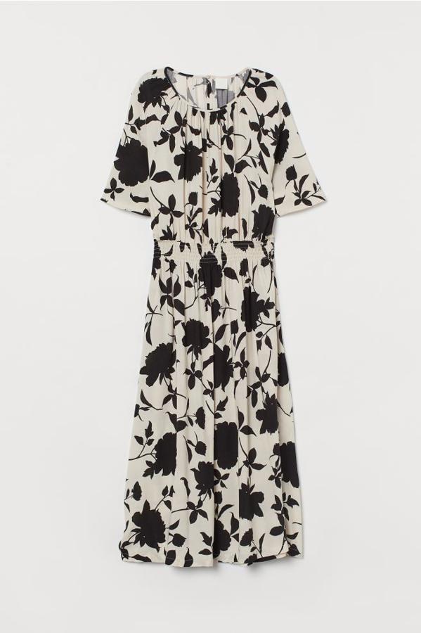 En viscosa vaporosa, con cuello redondo y fruncido decorativo en el escote, este vestido de fondo beige con estampado floral en negro viene con media manga raglán amplia y cuesta 19,99 euros. Podemos encontrarlo en H&M únicamente en las tallas S y M.