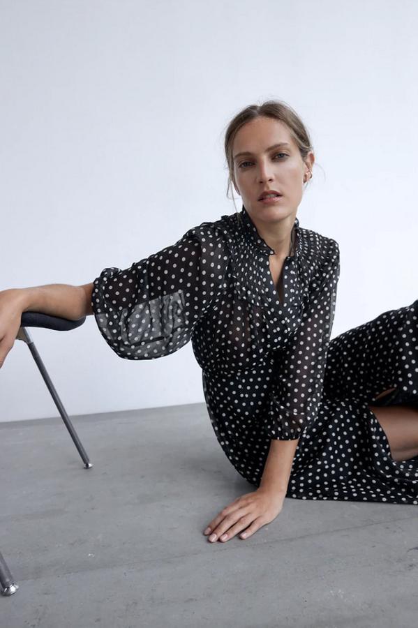 Con cuello subido con volante, escote de pico y manga larga, este vestido negro con lunares a contraste viene con bajo acabado en evasé y de 39,95 euros ha pasado a costar 19,99 euros. Está disponible entre las tallas XS y XXL en Zara.