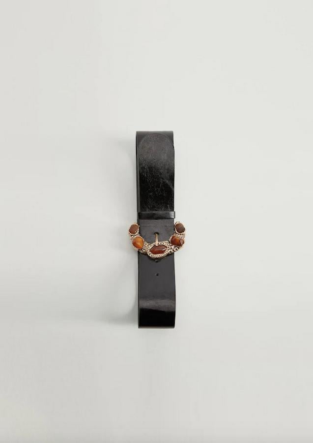 Ancho medio para este cinturón negro con hebilla en diseño de relieve con piedras incrustadas en tono ámbar. Cuesta 19,99 euros y está disponible en las tallas S, M y L.