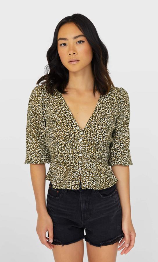 Con cuello de pico y manga tres cuartos, esta blusa con estampado mini animal en tonos caqui y negro es de Stradivarius y viene con detalle de frunce en la cintura y cierre frontal de botones. Cuesta 17,99 euros y está disponible entre las tallas XS y XL.