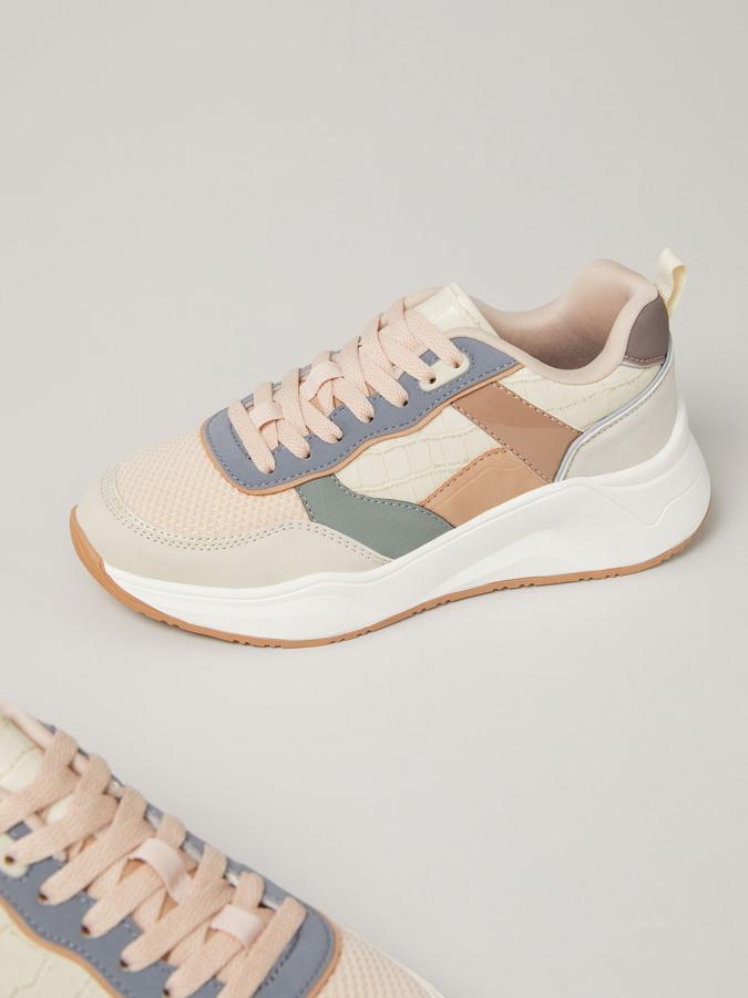 Estilo chunky y combinación de materiales, colores y texturas para estas zapatillas de Lefties con tirador en la parte trasera, suela con volumen y cierre de cordones. Tienen un precio de 27,99 euros y están disponibles entre los números 35 y 41.