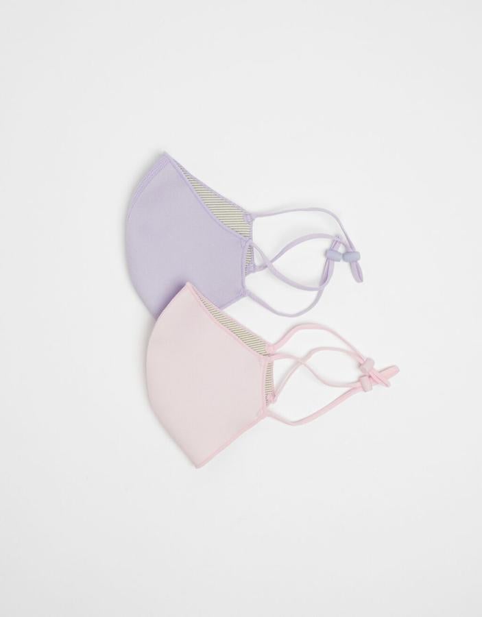 Rosa y lila en tonos pastel para este pack de dos cobertores faciales de Bershka reutilizables y que admiten 30 lavados. Cuestan 12,99 euros.