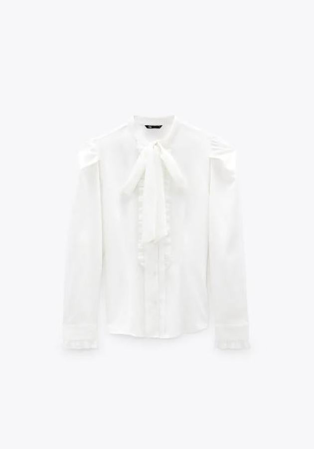 Camisa blanca con detalle de lazada en el cuello, de Zara (25,95 euros).