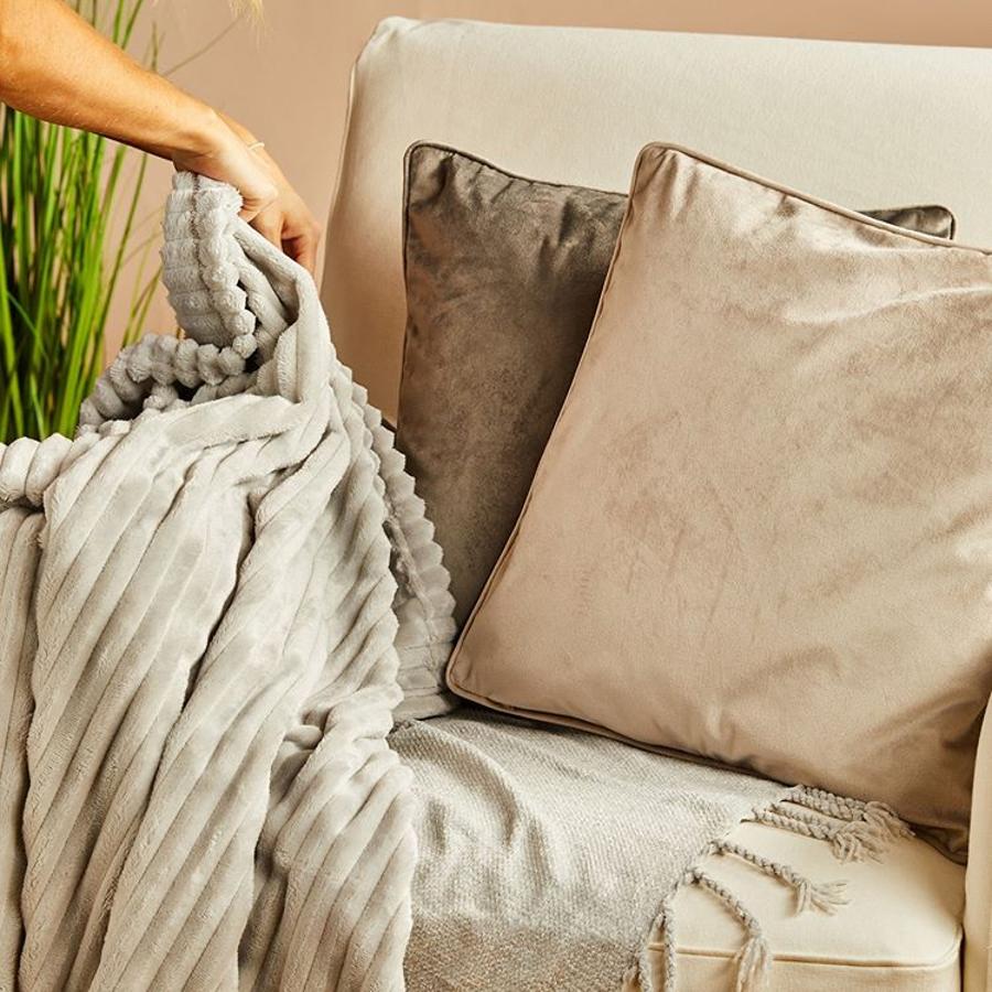 Con textura aterciopelada, esta manta gris perla de Primark Home invita al relax y a los maratones de series tiradas en el sofá.
