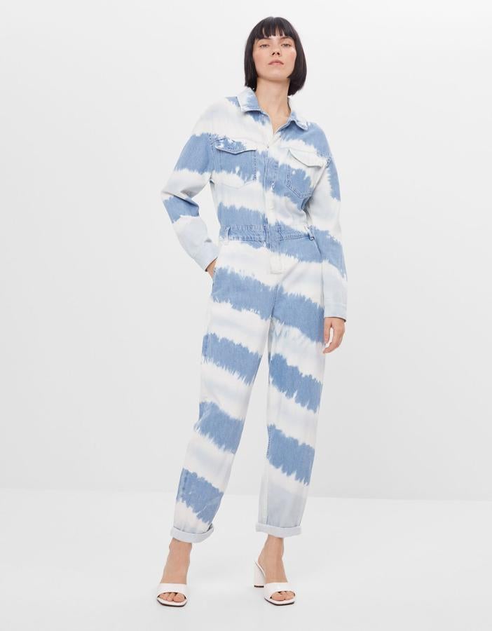 En Bershka han apostado por el print tie dye hasta en los monos denim. Este modelo hace rayas en diferentes tonos de azul y, aunque parezca complicado de llevar, es uno de los más trendy del momento (49,99 euros).
