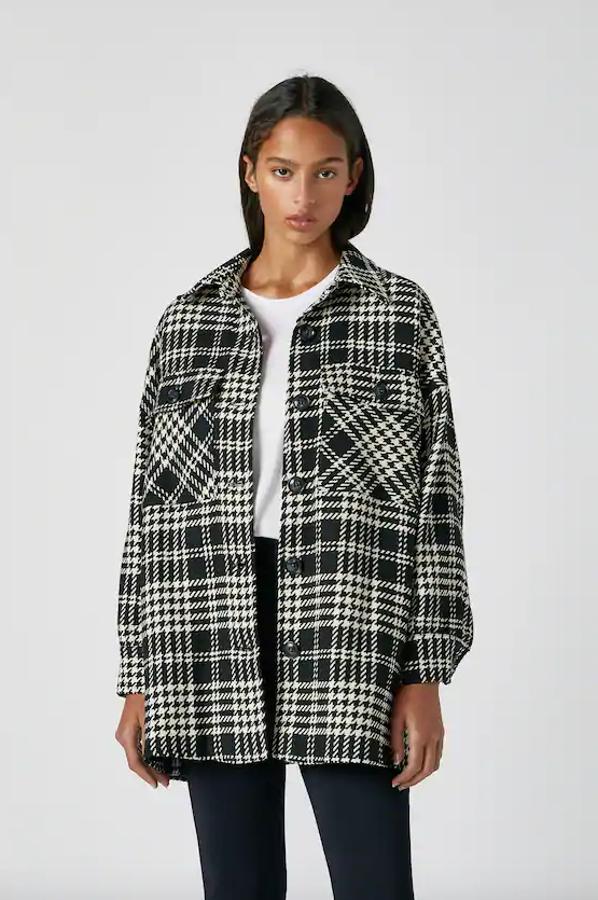 Con estampado de cuadros blancos y negros en diseño pata de gallo, bolsillos delanteros, cuello clásico y cierre de botones a tono, esta sobrecamisa de Pull&Bear tiene un precio de 29,99 euros y solo queda en las tallas S, M y L.