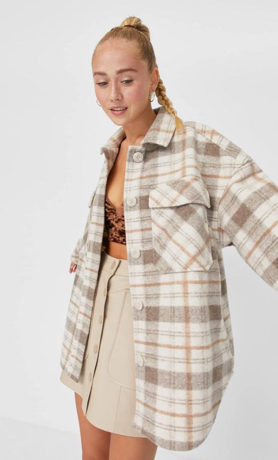 Con cuello de solapa y mangas largas, bolsillos delanteros con solapa y cierre frontal con botones, esta sobrecamisa de Stradivarius en crudo y beige con líneas en mostaza viene con bolsillos laterales ocultos en la costura. Tiene un precio de 35,99 euros y está disponible entre las tallas XS y XL.