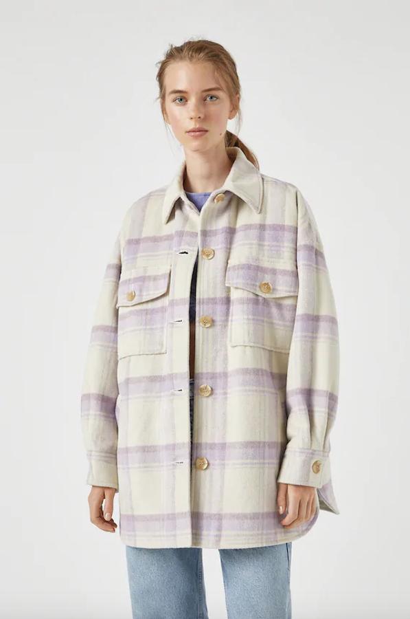 Cuadros en lila y blanco para esta sobrecamisa en tejido de paño con cuello clásico, cierre de botones en contraste y bolsillos delanteros de tapeta. Es de Pull&Bear, tiene un precio de 35,99 euros y está disponible entre las tallas XS y XL.