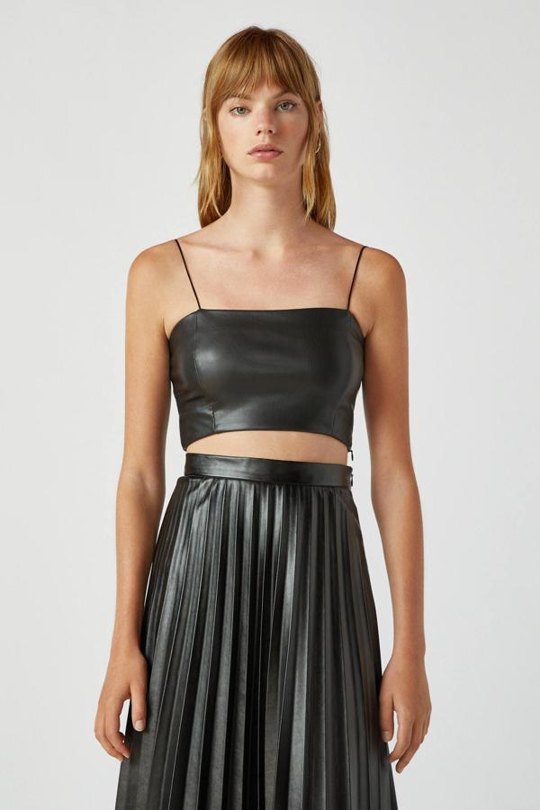 Disponible en color negro o tostado, este top cropped con efecto piel cuenta con forro interior y cuello recto. De tirantes, es de Pull & Bear y tiene un precio de 12,99 euros.