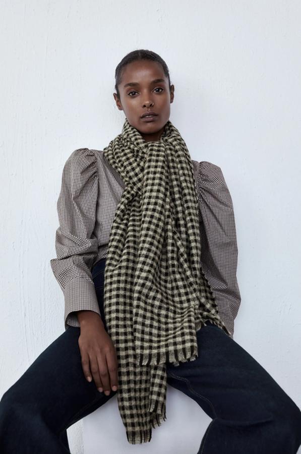 Confeccionado con tejido en mezcla de lana, este pañuelo de cuadros en blanco y negro es de Zara y viene con acabado desflecado. Podemos comprarlo por 19,95 euros.