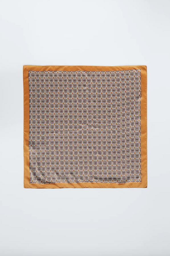 Enmarcado en tonos caramelo para este pañuelo corbatero satinado estampado en color marrón. Cuesta 9,95 euros.