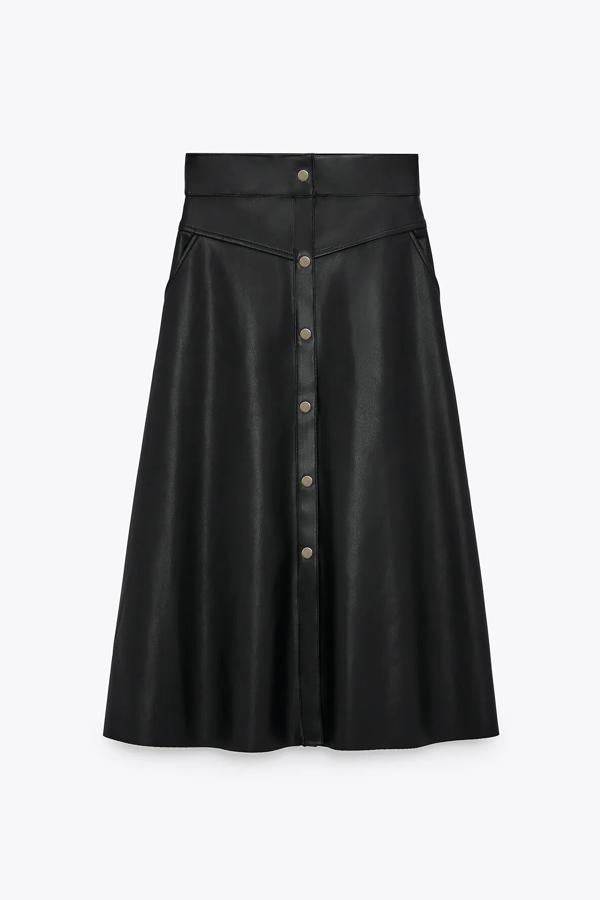 En color negro y con cierre frontal mediante botones metálicos a presión, esta falda midi con efecto piel es de tiro alto y cuenta con bajo acabado en evasé. Es de Zara y tiene un precio de 25,95 euros.
