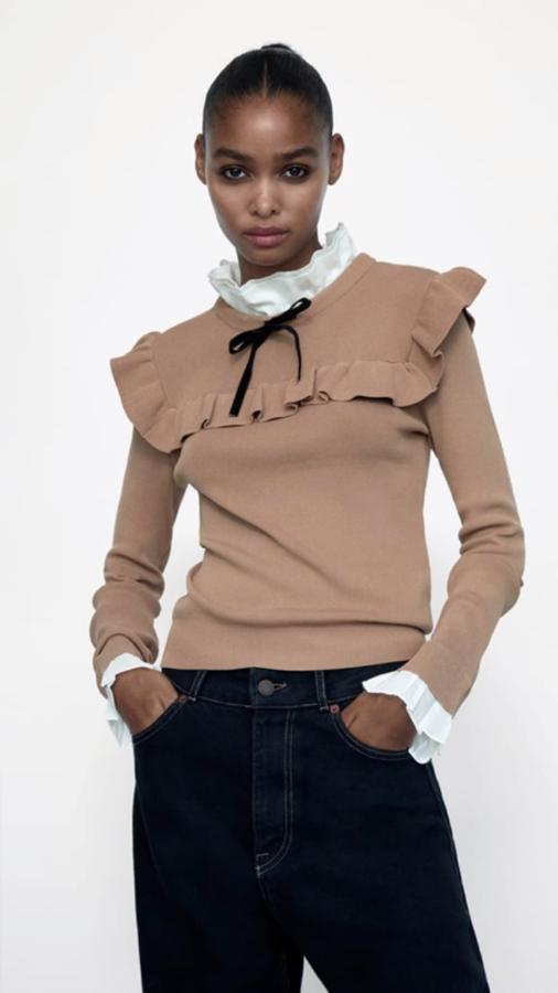 Jersey de Zara con efecto de superposición, cuello y mangas con volante y un discreto lazo negro en el falso cuello (25,95 euros).