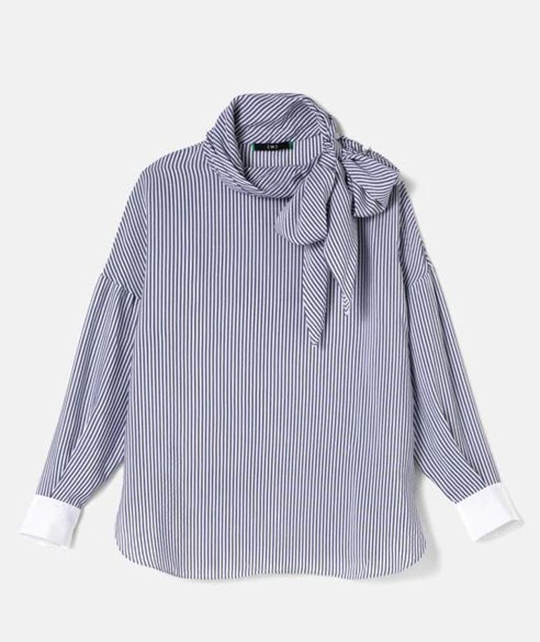 Blusa con lazada de popelín con estampado de rayas en azul marino y puños blancos en contraste, de la colección Woman Limited de El Corte Inglés. Cuesta 79,99 euros. Además de la blusa, Bábara lleva un vestido de Woman Limited, botas de Gloria Ortiz, bolso de Lauren Ralph Lauren y pendientes de El Corte Inglés.