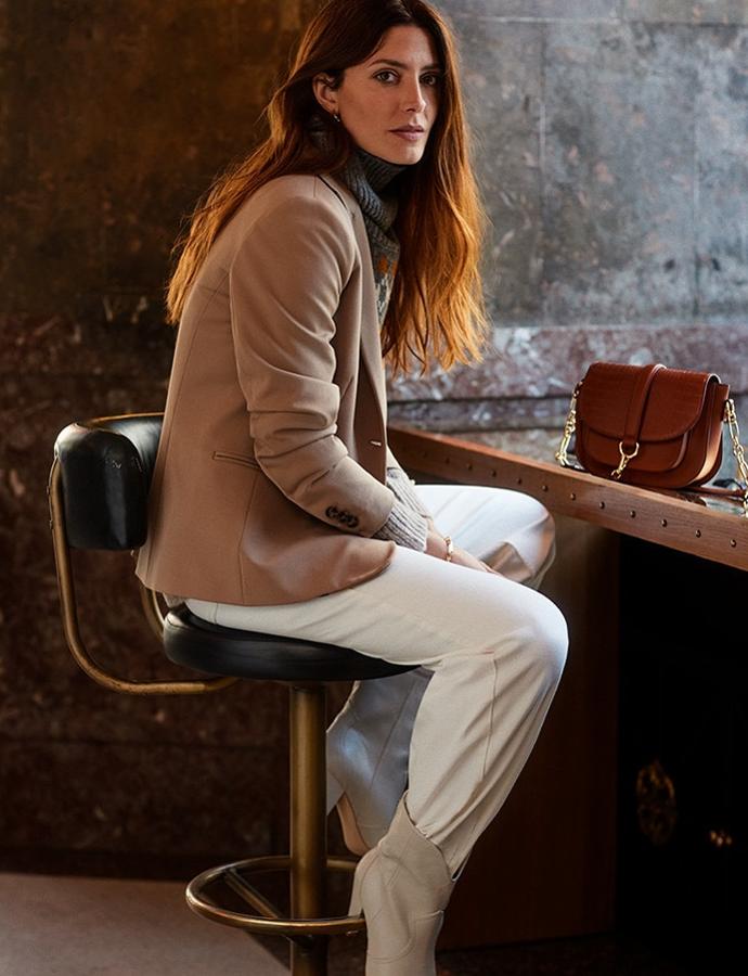 Los pantalones blancos son imprescindibles en un buen fondo de amario. ¡Y no solo en verano! Han venido para quedarse y ya son la prenda más buscada del otoño. El culotte es el modelo que mejor sienta y al que más partido le puedes sacar. En este caso, Bárbara lo lleva por dentro de las botas y lo ha combiando con un jersey de grecas y una blazer en color camel. Un look cómodo y relajado perfecto para cualquier día de la semana.