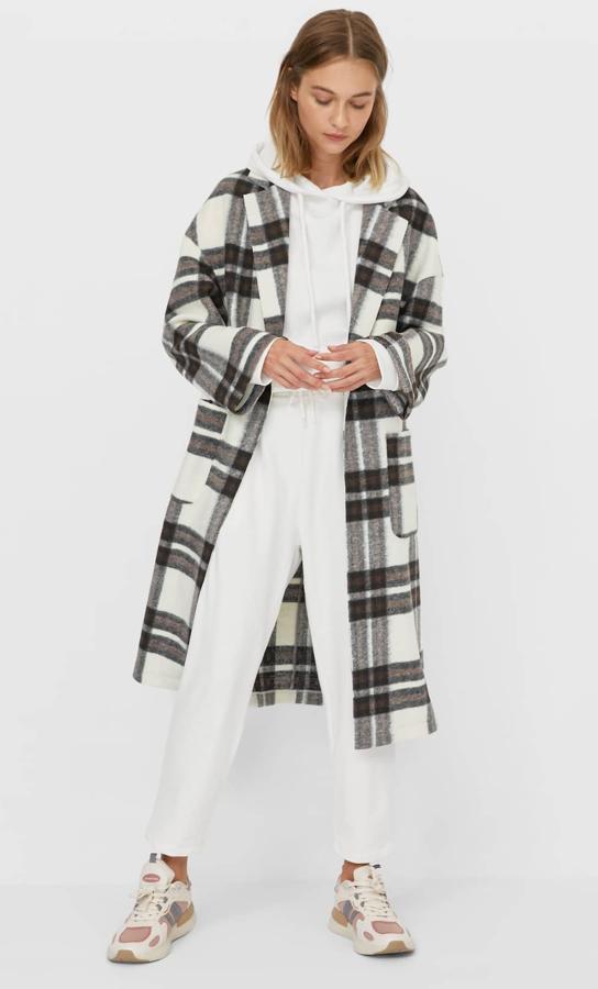 Este abrigo de punto con bolsillos delanteros y estampado de cuadros es de Stradivarius y tiene un precio de 39,99 euros.