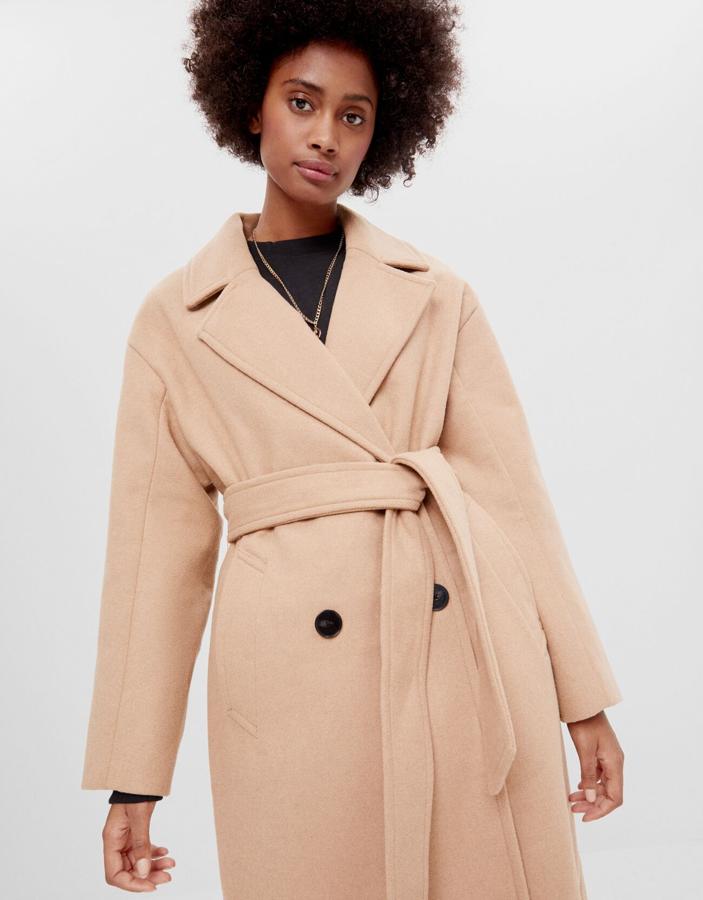 El clásico abrigo camel, de botonadura cruzada y cinturón, de la nueva colección de Bershka (49,99 euros).