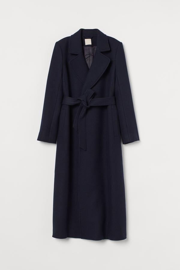 Largo hasta los pies, azul marino intenso y de corte masculino, abrigo con cinturón de H&M (149 euros).