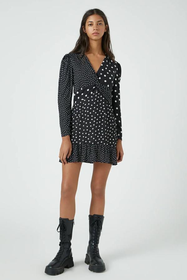 Este vestido de color negro con estampado de lunares blancos cuenta con escote de pico cruzado y detalle de volante en el bajo. Tiene un precio de 25,99 euros.
