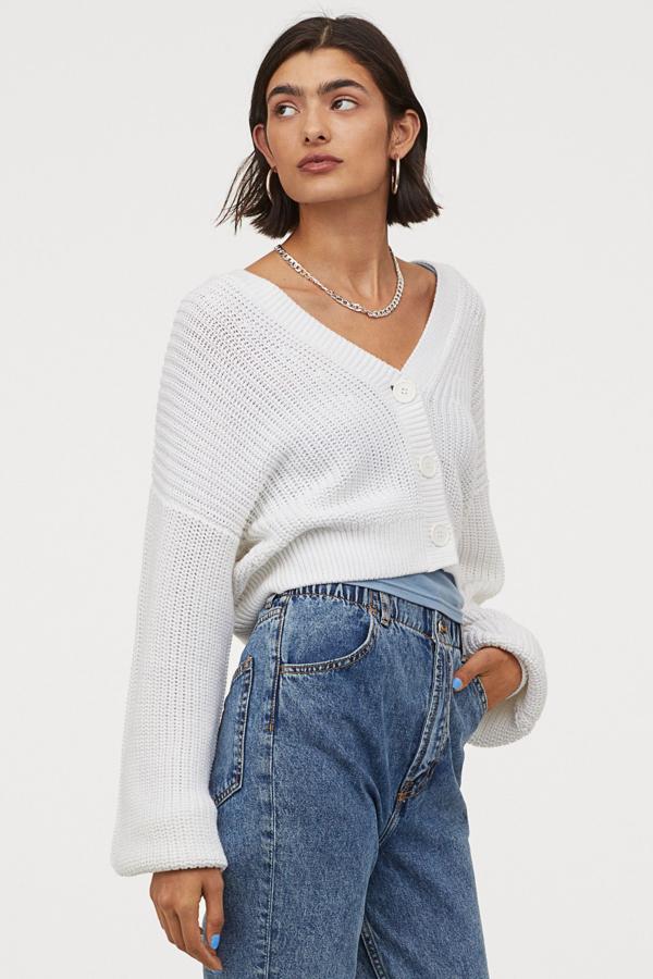 En punto suave de color blanco, este cárdigan corto con escote de pico pronunciado y botones grandes es de H&M y tiene un precio de 19,99 euros.