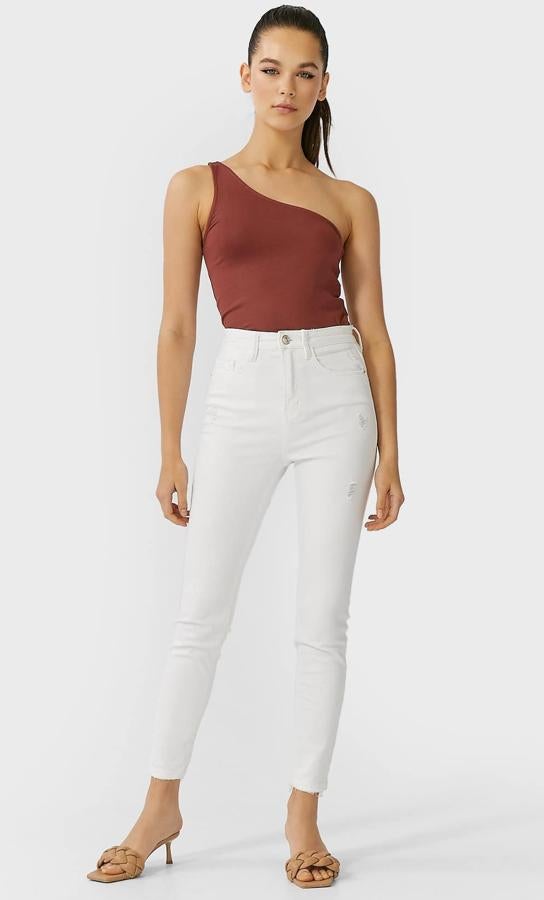 En color blanco, estos pantalones de tiro alto cuentan con diseño de cinco bolsillos y cierre con botón y cremallera. Son de Stradivarius y tienen un precio de 19,99 euros.
