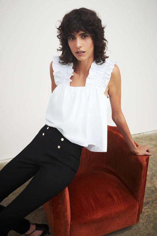 Con escote recto y tirantes anchos con volantes, este top blanco con bajo asimétrico es de Zara y tiene un precio de 22,95 euros.