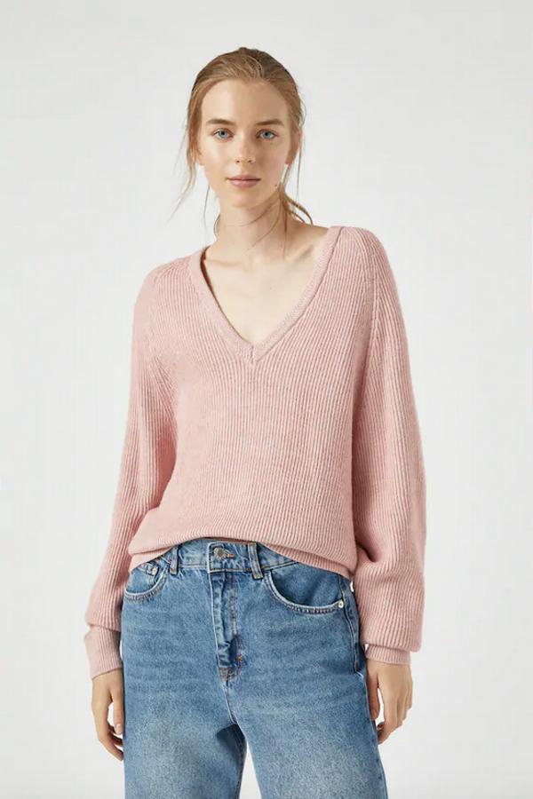 En tejido de punto inglés con detalles espigados, este jersey de Pull&Bear en rosa empolvado viene con escote en forma de pico y está confeccionado en mezcla de viscosa. Con un precio de 22,99 euros, está disponible entre las tallas XS y L.